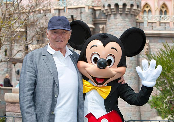 Sir Anthony Hopkins meets Mickey Mouse in front of Sleeping Beauty Castle at Disneyland park in Anaheim, California, on Monday, April 1, 2013.