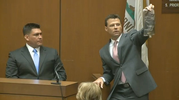 Sept. 29, 2011: Prosecutor David Walgren holds up a saline bag at Conrad Murray's involuntary manslaughter trial. Alberto Alvarez, Michael Jackson's former bodyguard, appears near him.