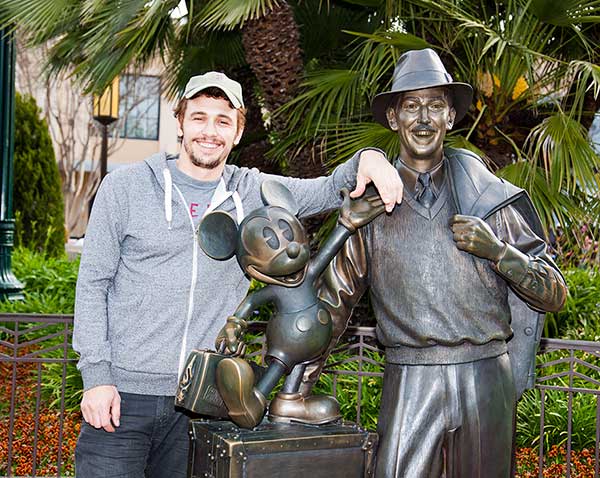 James Franco poses with a bronze statue of a...