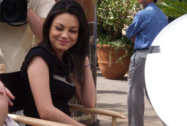 Mila Kunis appears laughing in a candid photo...