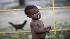 A child is seen in a a makeshift camp for...
