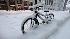 A snow covered bicycle is seen on the empty...