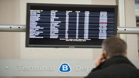 FILE - A traveler watches the departing board at Newark Liberty International Airport in Newark, NJ.