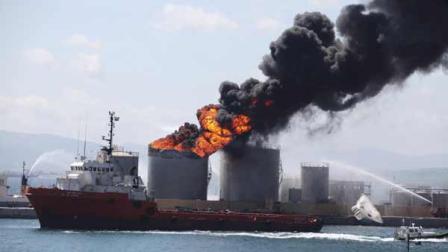 Flames and smoke billow from an oil tank in the docks of Gibraltar, Tuesday May 31, 2011. The cause of the explosion was not immediately known but two people were reported injured. (AP Photo/Alicia Jimenez)  