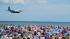 Spectators on Jones Beach watch as a plane zips...