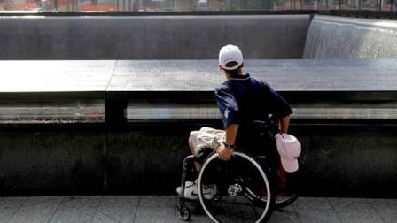 Marine Cpl. Tyler Huffman looks over a waterfall at the 9/11 Memorial in New York, Wednesday, July 4, 2012. Huffman was visiting the memorial with other wounded veterans as a part of a trip organized by the Stephen Siller Tunnel to Towers Foundation, which is helping to build accessible homes for the wounded veterans. (AP Photo/Seth Wenig)