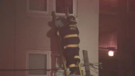 A firefighter helps an elderly man down a ladder to safety as crews worked to contain a blaze at an Atlantic City rooming house early Sunday morning.
