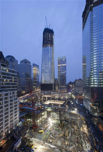 One World Trade Center, center, now up to the 100th floor, and Four World Trade Center, right, overlook the ongoing construction of the site, Sunday, April 1, 2012 in New York. The unfinished One World Trade Center is one of the city's tallest structures. If construction continues at its current pace, it will pass the Empire State Building this spring. Four WTC will top out at 72 floors. (AP Photo/Mark Lennihan)