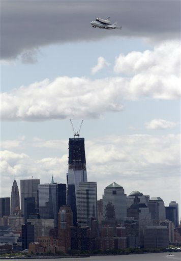 Space shuttle Enterprise, riding on the back of the NASA 747 Shuttle Carrier Aircraft, cruises by One World Trade Center as it makes its way to John F. Kennedy International Airport seen from Union City, N.J., Friday, April 27, 2012. Enterprise is expected to go on display at the Intrepid Sea Air and Space Museum in New York. (AP Photo/Julio Cortez)