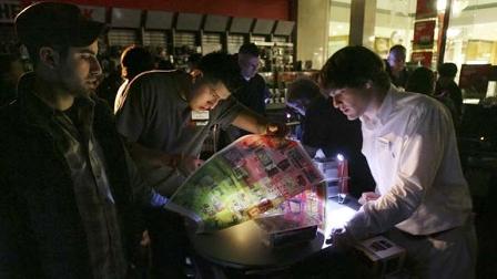 Adam Ciccarino, left, of Manhattan, purchases Playstation 3 controllers during a temporary power outage at RadioShack in the Bridgewater Commons with the assistance of assistant manager Christopher Sanchez and sales associate Michael Byrne, right, as Black Friday shoppers hit the stores in Bridgewater, N.J., before dawn to take advantage of sales Friday, Nov. 27, 2009.