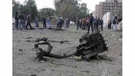 Iraqis gather at the site of a car bomb attack in Baghdad, Iraq, Monday, Jan. 25, 2010. Three parked car bombs struck near three Baghdad hotels popular with Western journalists and businessmen.