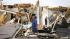 Juan Ventura stands inside what remains of his...