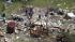 In an aerial photo, people assess the damage in...