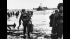 U.S. assault troops, laden with equipment, wade...