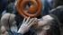 A man blows a horn as people gather at the...
