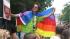Andres Coloma, with a pride flag draped around...