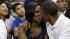 President Barack Obama, left, leans in to kiss...