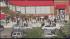 Throngs of people lined up outside the...