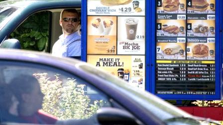 In this file photo, customers view the menu in the drive through line at a Burger King in Portland, Ore. (AP Photo/Don Ryan, File)