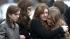 Mourners comfort one another as they leave a...