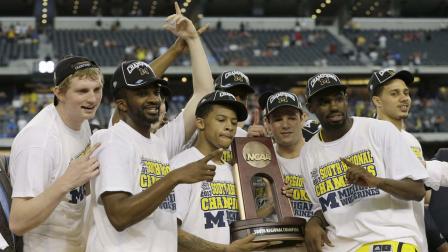 Michigan celebrates with the trophy after a regional final game against Florida in the NCAA college basketball tournament, Sunday, March 31, 2013, in Arlington, Texas. Michigan won 79-59 to advance to the Final Four. (AP Photo/David J. Phillip)