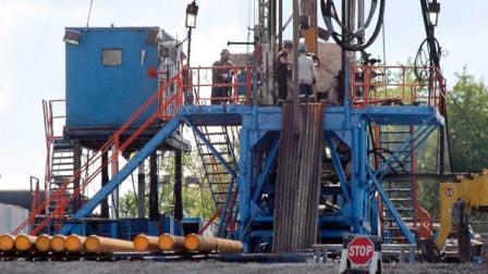  In this   file photo, a crew works on a gas drilling rig at a well site for shale based natural gas in Zelienople, Pa.  