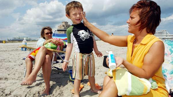 Bernadine Boyce, of Allentown, Pa., applies sunscreen to Bruno Barber, 5, of Atlantic City, as mom, Natalia Barber, watches in Atlantic City, N.J., Friday, June 9, 2006. Experts say the best protection against dangerous cancers like melanoma are sunscreens that contain zinc oxide, titanium dioxide or avobenzone. (AP Photo/Mary Godleski)