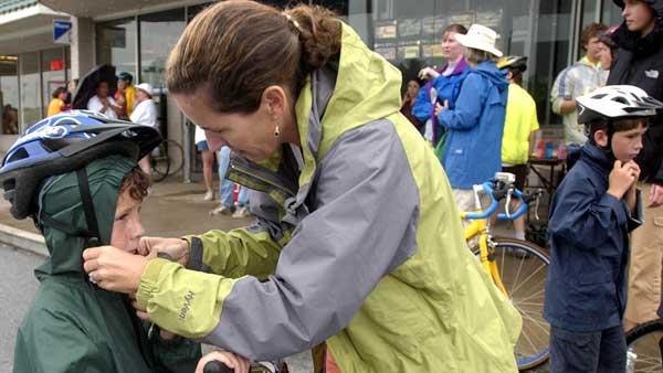 A woman helps her son put on his helmet in this file photo. (AP Photo/Mary Ann Chastain)