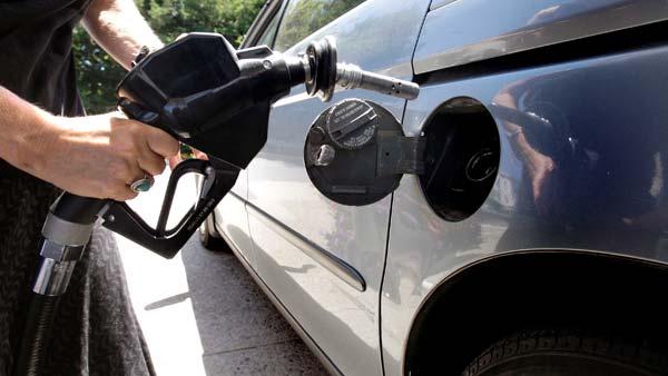 In this July 16, 2008 file photo, a motorist gets ready to pump gasoline into her minivan at the Mobil Station in Andover, Mass. A reader-submitted question about the cost of gas is being answered as part of an Associated Press Q&A column called Ask AP. (AP Photo/Charles Krupa)