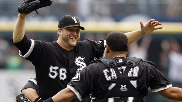 Chicago White Sox pitcher Mark Buehrle, left, is embraced by teammates including catcher Ramon Castro after throwing a perfect game against the Tampa Bay Rays in a baseball game, Thursday, July 23, 2009, in Chicago. The White Sox won 5-0. (AP Photo/Jim Prisching)