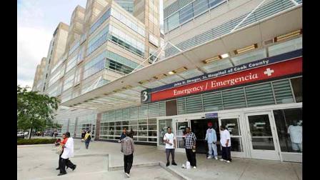 In this July 30, 2009 photo, people stand in front the the emergency room entrance at Stroger Hospital. (AP Photo/Paul Beaty)