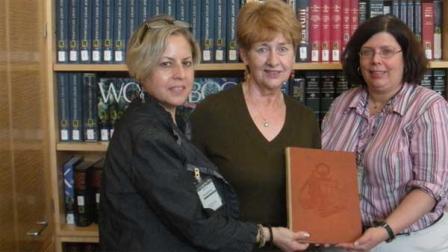 LaGrange Park Public Library Director of Circulation Services Ursula Stanek, center, holds the original book with librarians at the Holocaust Museum in Washington, D.C.