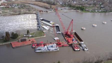 A crane known as the HERCULES unloads cargo from one of the submerged barges near the Marseilles Dam in Marseilles, Ill., April 24, 2013. Salvage operations continued to remove the remaining barges. Coast Guard photo by Petty Officer 3rd Class John Schleicher.