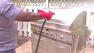 man sprays down grill