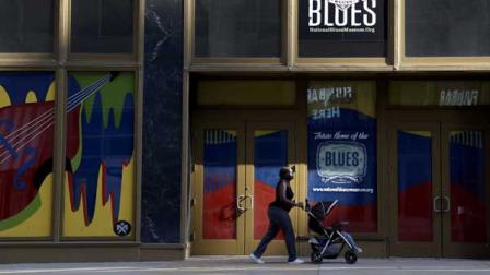 In this Wednesday, Sept. 25, 2013 photo, a woman pushes a stroller past the site of the National Blues Museum, set to open next year, in St. Louis. Casual Blues fans may not immediately think of St. Louis when considering the genre, but organizers of the project say the city has its own rich musical history making it a deserving home for the national museum. 