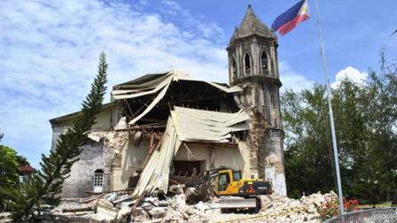 A crane shifts through the rubble of the damaged Our Lady of Assumption Parish church following a 7.2-magnitude earthquake, at Dauis in Bohol, central Philippines, Tuesday Oct. 15, 2013. The tremor collapsed buildings, cracked roads and toppled the bell tower of the Philippines oldest church Tuesday morning, causing multiple deaths across the central region and sending terrified residents into deadly stampedes. 