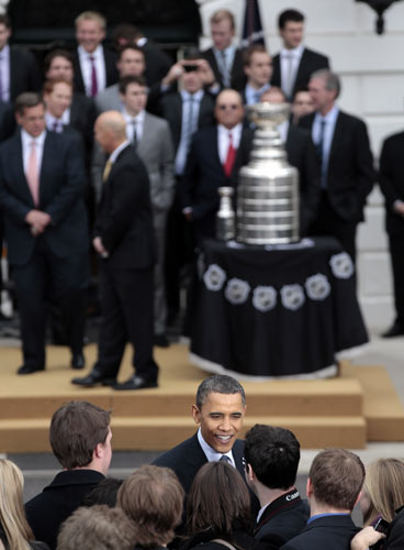 President Barack Obama, center, greets guest...