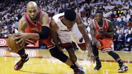 Chicago Bulls forward Taj Gibson, left, and Miami Heat guard Norris Cole battle for a loose ball as guard Nate Robinson, far right, watches