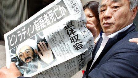 A man shows an extra edition of a Japanese newspaper in Tokyo Monday, May 2, 2011, reporting Osama bin Laden, the glowering mastermind behind the Sept. 11, 2001, terror attacks was killed in an operation led by U.S. forces. Japanese headlines read: Is Bin Laden dead? His remains were taken custody, said President.