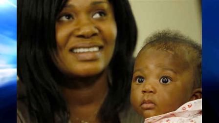 Nadine Devilme talks to her baby, Jenny, during a press conference, Tuesday, April 6, 2010 in Miami Gardens, Fla. The parents were united with their baby yesterday, after the baby had been taken to Miami for medical treatment after the earthquake in Haiti.