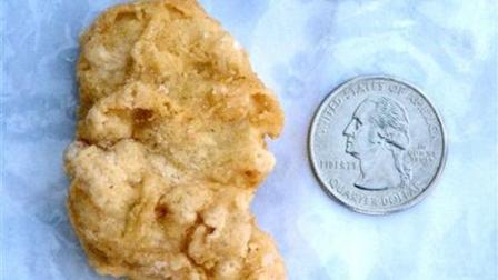 FILE - In this Feb. 21, 2012 file photo, a McDonalds Chicken McNugget found by Rebekah Speight of Dakota City, which she believes resembles President George Washington is placed next to a U.S. quarter dollar bearing the image of the president. The Sioux City Journal reports Thursday, March 8, 2012 that the top bidder for the 3-year-old McNugget has backed out. The bidder submitted $8,100 in the auction that ended Monday. (AP Photo/Sioux City Journal, Nathan Robson, File)