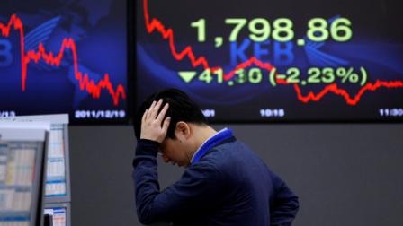 A currency trader reacts in front of the screen showing the Korea Composite Stock Price Index at the foreign exchange dealing room of the Korea Exchange Bank headquarters in Seoul, South Korea, Monday, Dec. 19, 2011. (AP Photo/Lee Jin-man)