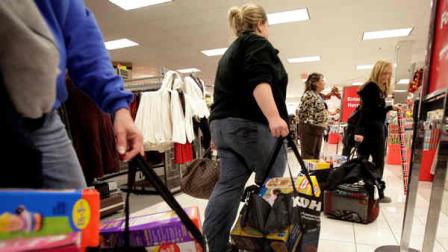 In this Nov. 25, 2011 file photo, customers wait in line to pay for their items at a Kohls department store in La Habra, Calif. Despite all the worrying by retailers, the holiday 2011 shopping season is wrapping up to be bigger than anyone expected.