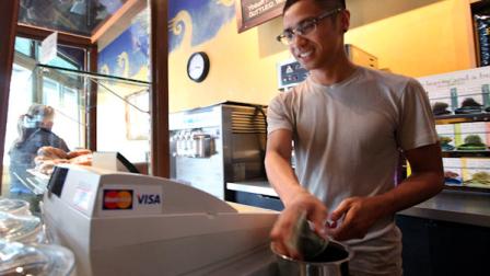 In this photo taken Thursday, April 19, 2012, barista Michael Bledsoe adds to his tip jar after making a drink for a customer in a coffee shop in Seattle. The college class of 2012 is in for a rude welcome to the world of work. A weak labor market already has left half of young college grads either jobless or underemployed in positions that dont fully use their skills and knowledge. (AP Photo/Elaine Thompson)