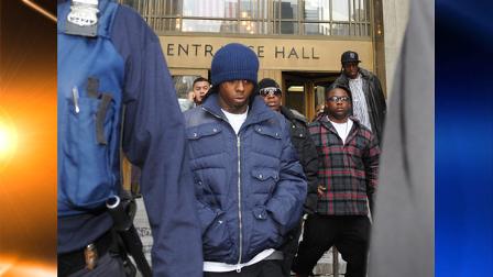 Rapper Lil Wayne, right, exits Manhattan criminal court, Tuesday, Feb. 9, 2010, in New York. Sentencing in the hip-hop artists 2007 gun-possession case was postponed until March 2 due to his need for oral surgery. (AP Photo/Louis Lanzano)
