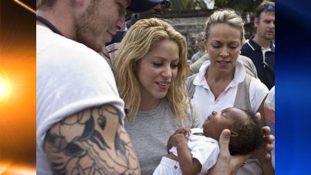 Colombian singer Shakira looks at a newborn child during a visit at the Petionville Golf Club makeshift camp in Port-au-Prince, Sunday, April 11, 2010. Shakiras Pies Descalzos foundation will finance the construction of a new school in Port-au-Prince. (AP Photo/Ramon Espinosa)