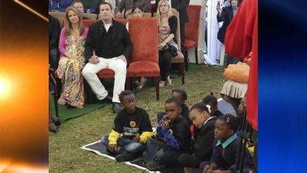 John Travolta and his wife Kelly Preston, left, sit with children at the Nelson Mandela Childrens Fund headquarters in Johannesburg, Saturday, June 12, 2010. Travolta is in the country for five days as a goodwill ambassador for the Australias soccer team at the World Cup soccer tournament. (AP Photo/Denis Farrell)