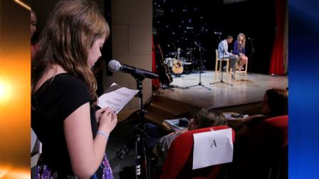 Ella Vignola, left, 12, a student at Middle School 255 in Manhattan, asks a question of Taylor Swift, right, during the Read Now with Taylor Swift event sponsored by Scholastic, Inc., in New York, Wednesday, Oct. 27, 2010. TV Personality Nick Cannon, seated next to Swift, was the events host. (AP Photo/Richard Drew)