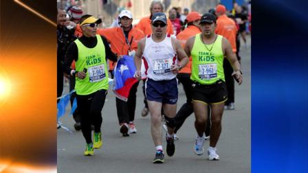 Chilean miner Edison Pena, center, approaches the finish line with supporters in the New York City Marathon in New York, Sunday, Nov. 7, 2010. (AP Photo/Kathy Willens)