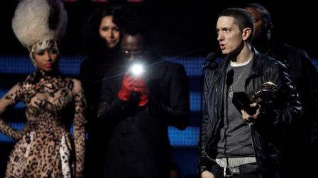 Eminem, right, accepts the award for best rap album, as Nicki Minaj and will.i.am look on at the 53rd annual Grammy Awards on Sunday, Feb. 13, 2011, in Los Angeles. (AP Photo/Matt Sayles)